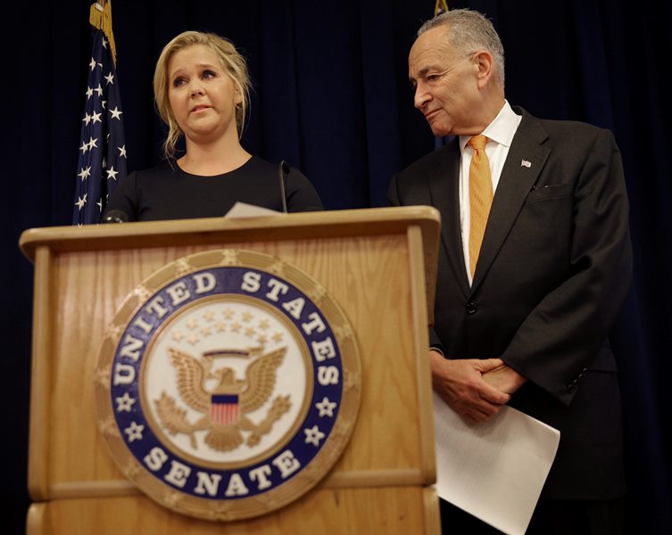 Actress Amy Schumer becomes emotional during a news conference while her distant cousin, New York Sen. Chuck Schumer, looks on in New York, Monday, Aug. 3, 2015. 