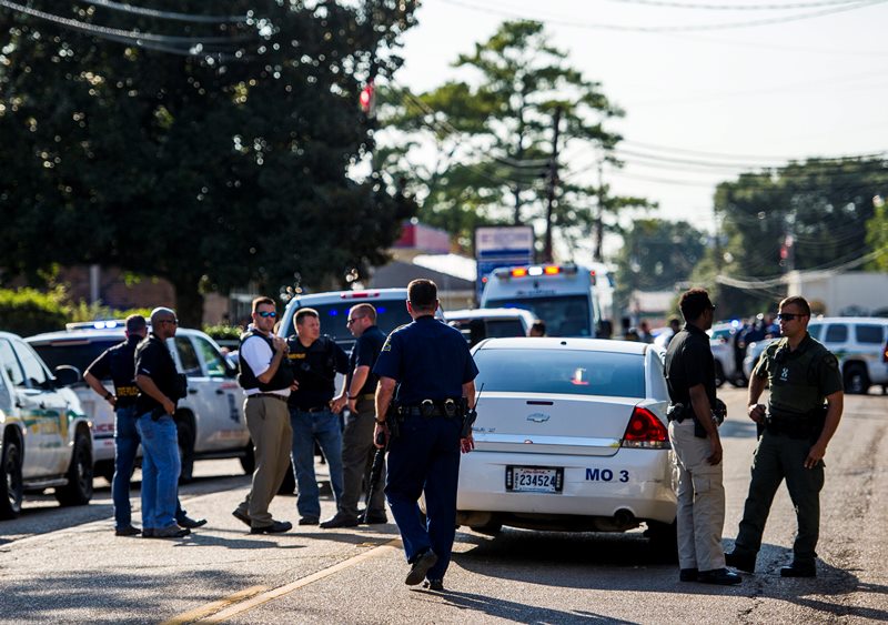 Police stand on the scene of a shooting in Sunset, La., Wednesday, Aug. 26, 2015. A police officer and two other people were shot in southwestern Louisiana, Louisiana State Police Superintendent Mike Edmonson said. 