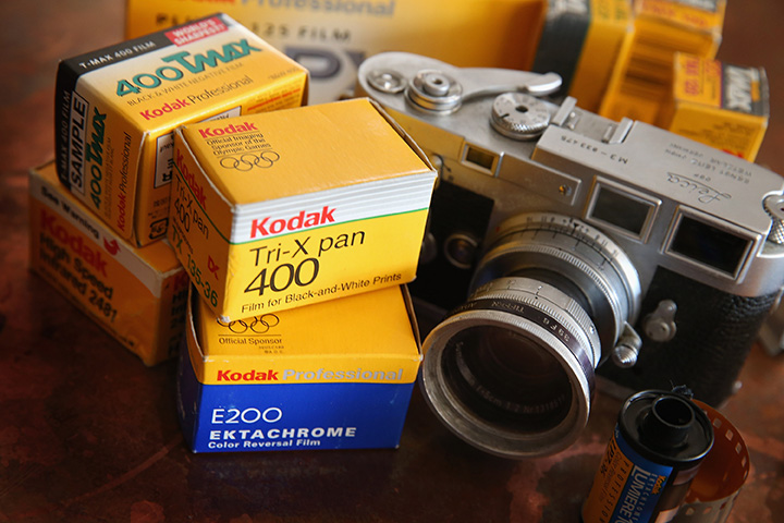 Kodak film is seen alongside a vintage Leica M3 35mm rangefinder camera. 