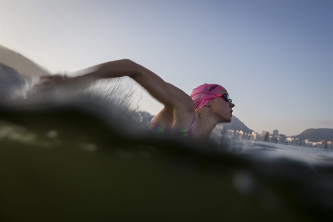 A triathlete trains in the waters off Copacabana Beach, despite published warnings that water in the area was "unfit" for swimming, in Rio de Janeiro, Brazil, Friday, July 31, 2015. 