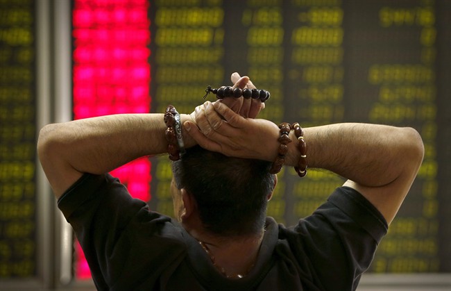 A Chinese investor monitors stock prices at a brokerage house in Beijing, Monday, Aug. 24, 2015. 