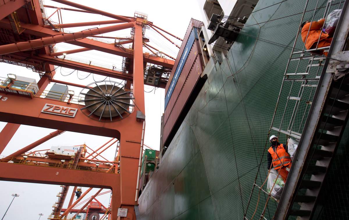 Reynaldo Germano, bottom, and Ramil Ramirez, both from the Philippines, take supplies on board the cargo ship Ital Usodimare at port in Vancouver, B.C., on Sunday December 23, 2012. 