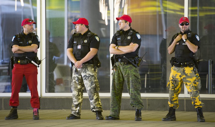 Police officers stand guard outside a building in Montreal, Sunday, June 14, 2015.