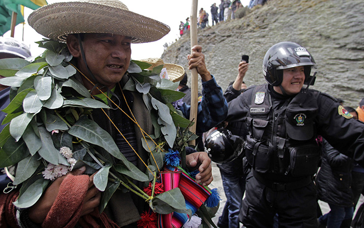 Indigenous leader Adolfo Chavez, left, is escorted by police officers, as he arrives in La Cumbre, Bolivia. The leader who has been openly critical of President Evo Morales' push to drill for oil and develop mining on traditional native lands in the eastern lowlands, was arrested by Bolivian authorities.
