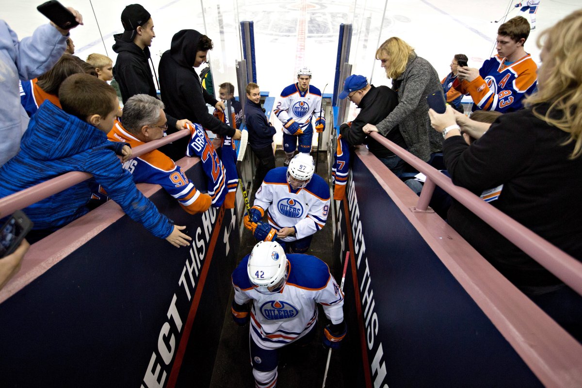 Fans watch as Edmonton Oilers Connor McDavid (97) Anton Slepyshev (42) and Andrej Sekera (2) leave the ice after warm-up before the Oilers rookies play an exhibition game with University of Alberta Golden Bears in Edmonton, Alta., on Wednesday September 16, 2015. 