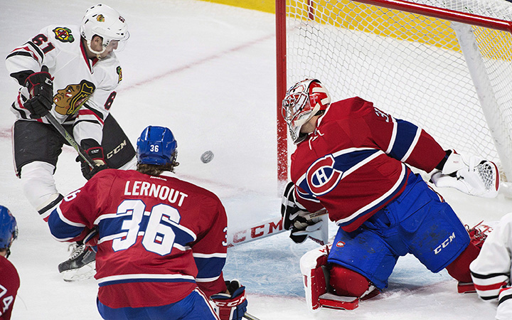 Montreal Canadiens goaltender Carey Price, right, is scored on by Chicago Blackhawks' Garrett Ross, as Canadiens' Brett Lernout defends during first period NHL pre-season hockey action in Montreal, Friday, September 25, 2015. 