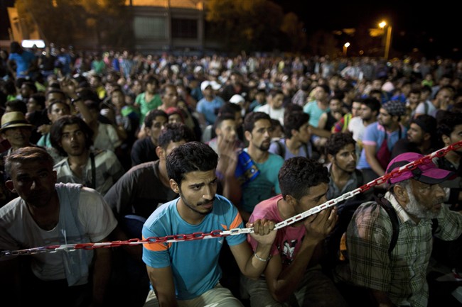 Syrian refugees wait at the port of Lesbos island, Greece, to board a ferry travelling to Athens, on Monday, Sept. 7, 2015. An immigration expert says recent announcements of provincial support for Syrian refugees fail to address the question of who would foot the bill to sponsor more immigrants from the war-ravaged country. 