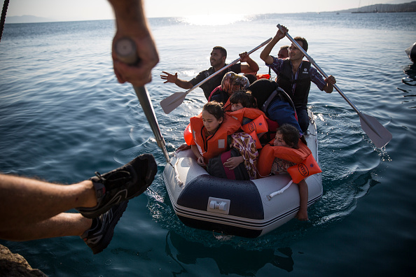 A Syrian family arrive in an inflatable dinghy at Kos ferry port after the crossing from Turkey on August 30, 2015 in Kos, Greece. Migrants from many parts of the Middle East and African nations continue to flood into Europe before heading from Athens, north to the Macedonian border.   (Photo by Dan Kitwood/Getty Images).