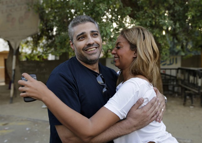 Canadian Al Jazeera English journalist Mohamed Fahmy hugs his wife Marwa Omara after being released from Torah prison in Cairo, Egypt, Wednesday, Sept. 23, 2015.