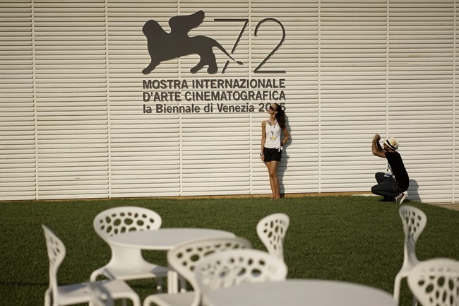 People take souvenir photos in front of the logo of the 72nd edition of the Venice Film Festival, at the Venice Lido, Monday, Aug. 31, 2015. 