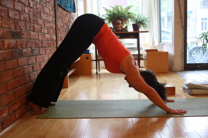 Ambaa yoga co-founder Michelle Sands does a downward facing dog against a wall in the studio, Thursday, September 10, 2015.