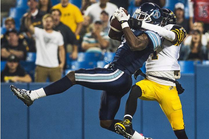 Toronto Argonauts' Akwasi Owusu-Ansah intercepts the ball from Hamilton Tiger-Cats' Tiquan Underwood during first half CFL action in Toronto on Friday, September 11, 2015. The Argonauts are being forced out of their home stadium by baseball's powerhouse Blue Jays.The CFL club will have to play its Oct. 6 home game against the Redblacks in Ottawa because the Jays could be playing in the American League wild-card game that day at Rogers Centre.