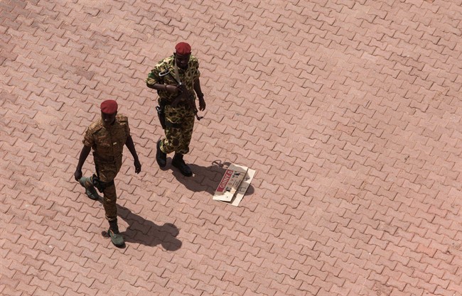 Burkina Faso troops parole near the entrance to the Libya hotel where talks about the recent coup were taking place in Ouagadougou, Burkina Faso, Sunday, Sept. 20, 2015. Violence broke out at the main hotel in Burkina Faso's capital on Sunday where talks were taking place with regional mediators as demonstrators opposed to last week's coup clashed with supporters of the military. (AP Photo/Theo Renaut).