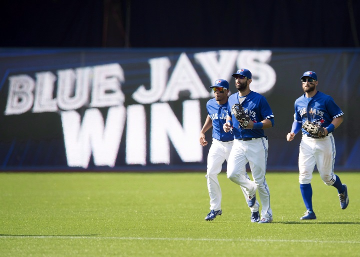 Toronto Blue Jays, from left to right, Ben Revere, Jose Bautista, and Kevin Pillar celebrate the Blue Jays' win over the Baltimore Orioles on September 5, 2015.