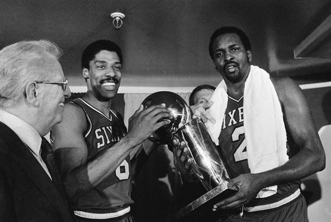 In this May 31, 1983 file photo, Philadelphia 76ers Julius Erving, left, and Moses Malone, right, hold the NBA Championship trophy after defeating the Los Angeles Lakers in Los Angeles.