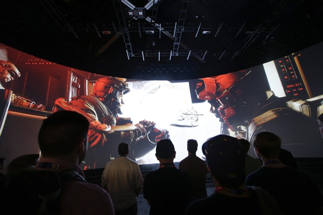 People watch the "Call of Duty: Advanced Warfare" video game trailer at the Activision booth at the Electronic Entertainment Expo, in Los Angeles.
