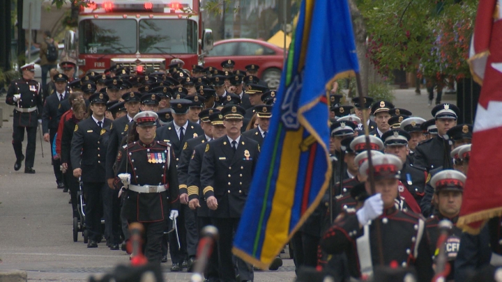A procession of firefighters marches to the Police Officers and Firefighters Tribute Plaza outside the municipal building for a ceremony honouring 42 fallen Calgary firefighters.