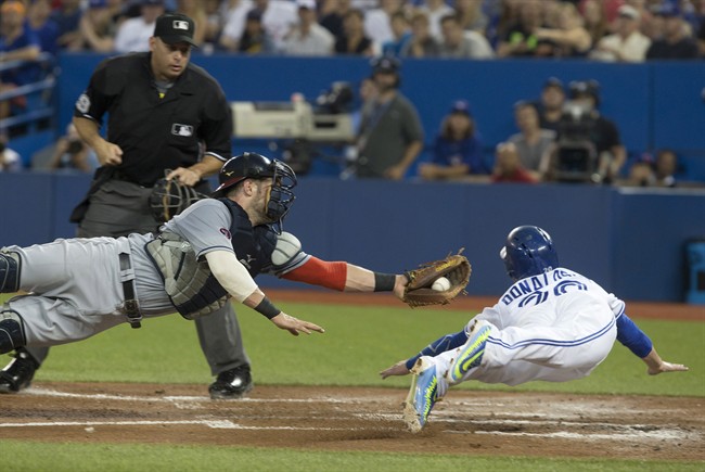 Toronto Blue Jays' Josh Donaldson, right, slides into home to score past Cleveland Indians catcher Yan Gomes after a sacrifice fly from Blue Jays' Troy Tulowitzki during second inning AL baseball action in Toronto on Wednesday September 2 , 2015. THE CANADIAN PRESS/Chris Young.