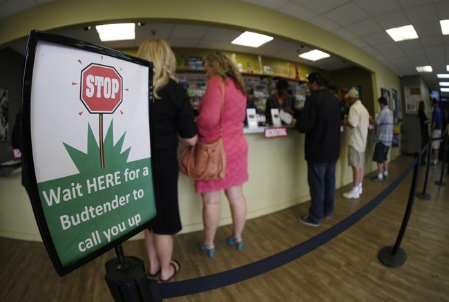 In this photograph taken with a fisheye lens Saturday, April 25, 2015, buyers make their purchases at the counter as a contingent of lawmakers, their staffers and a handful of lobbyists tour one of two retail and grow operations for both medical and recreational marijuana in northeast Denver. 
