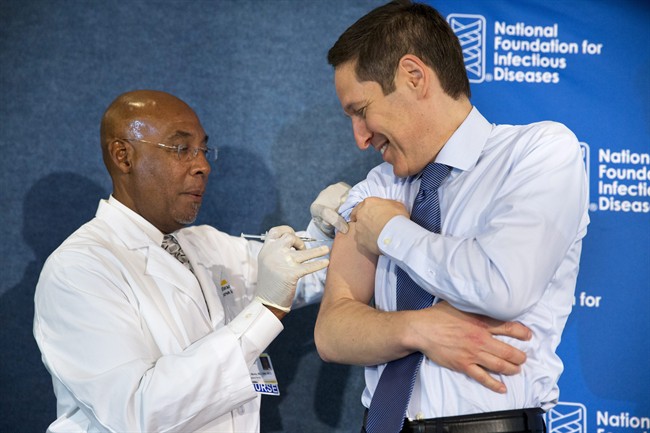 Prevention Director Dr. Tom Frieden, right, receives a flu shot from nurse B.K. Morris during an event about the flu vaccine, Thursday, Sept. 17, 2015, at the National Press Club in Washington.