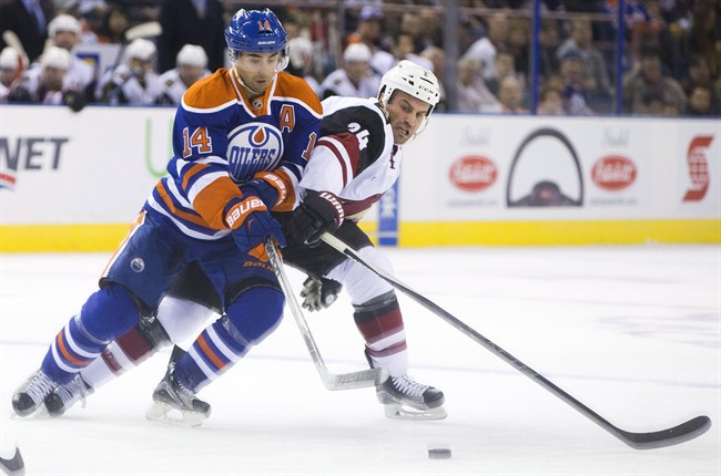 Arizona Coyotes' Brad Hunt, right, and Edmonton Oilers' Jordan Eberle (14) battle for the puck during first period NHL pre-season action in Edmonton on Tuesday, September 29, 2015.