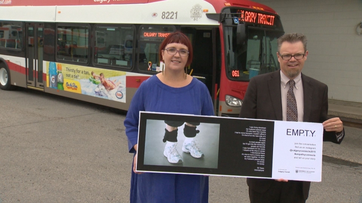 Suzanne Goopy, an associate professor of nursing at the U of C and Calgary Transit director Doug Morgan hold up one of the 10 posters on display on CTrains and buses as part of the EMPaThY? campaign,.