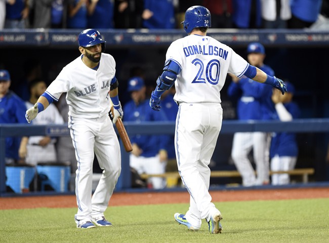 Toronto Blue Jays' Josh Donaldson celebrates with teammate Jose Bautista after hitting a solo home run against the Tampa Bay Rays during third inning AL MLB baseball action in Toronto on Friday, Sept. 25, 2015. 