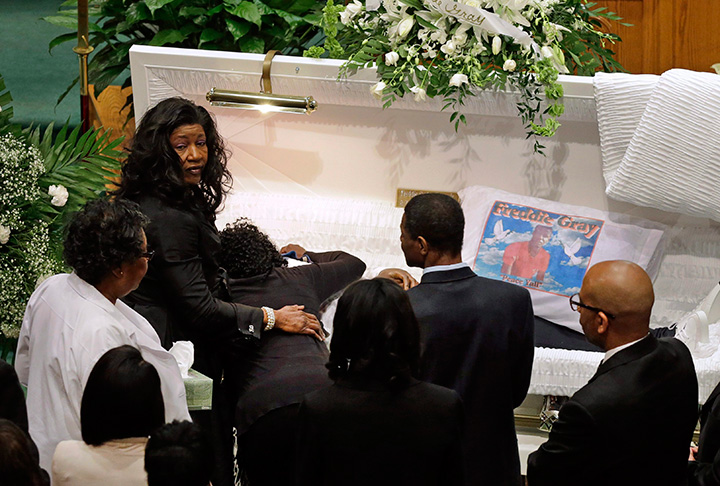 In this April 27, 2015 file photo, Gloria Darden, mother of Freddie Gray, is comforted as she embraces his body before his funeral at New Shiloh Baptist Church in Baltimore. 