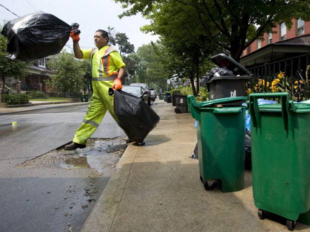 File photo of a garbage collector picking up bags in the city. 