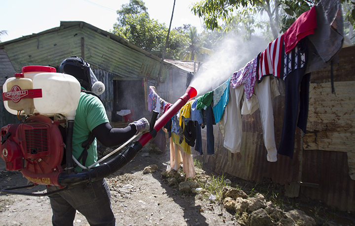 A man fumigates between houses at the Santo Domingo's neighborhood La Barquita to fight dengue fever.