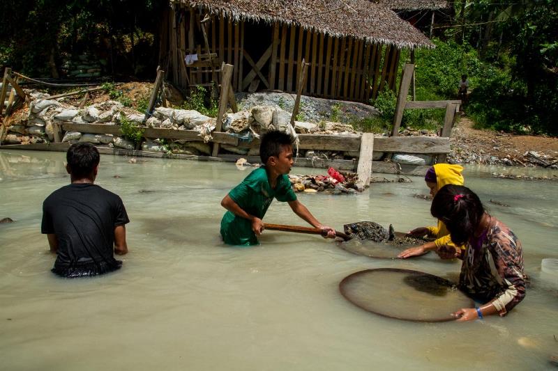 Children pan for gold along the Bosigon River in Malaya, Camarines Norte.