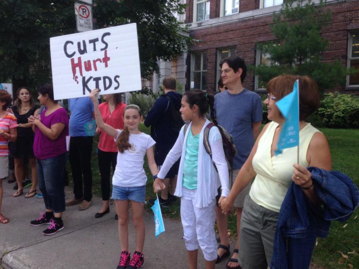 Molly hold up a sign during a protest against budget cuts against education in Quebec, Tuesday, September 1, 2015.