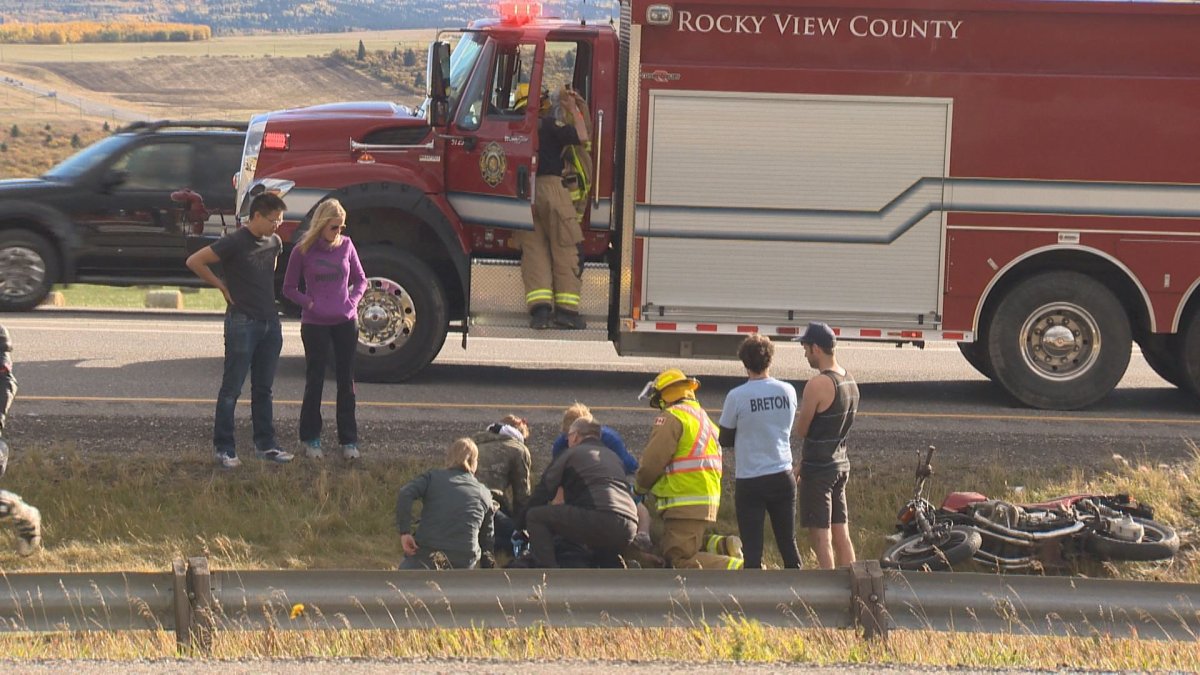 Witnesses and a fire crew from Rocky View County assist motorcycle crash victim on Trans-Canada Sunday afternoon.