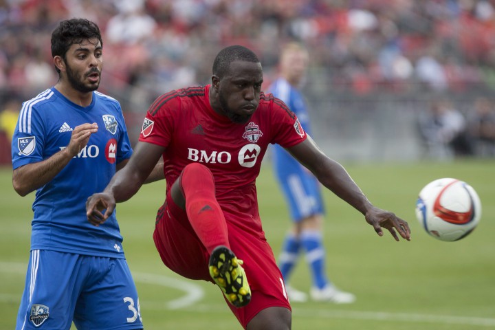 Toronto FC 's Jozy Altidore (right) shields the ball from Montreal Impact's Victor Cabrera during second half MLS action in Toronto on Saturday August 29, 2015.