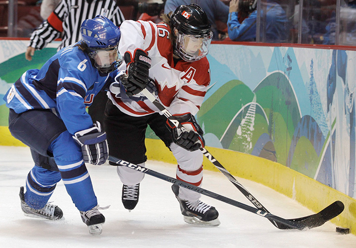 Canada's forward Jayna Hefford and Finland's defenceman Jenni Hiirikoski reach for the puck in the first period of a women's semi-final game at the Vancouver 2010 Olympics in Vancouver. 
