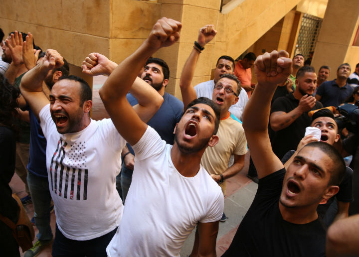Lebanese anti-government protesters shout slogans outside the Environment Ministry in support of activists staging a sit-in inside the ministry, in downtown Beirut, Lebanon, Tuesday, Sept. 1, 2015. 