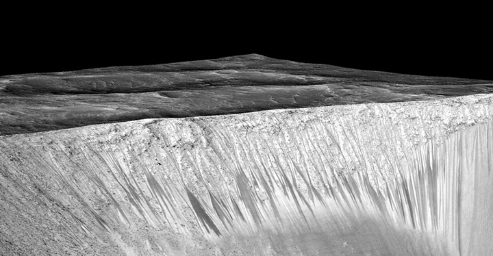Dark narrow streaks, called recurring slope lineae, emanating out of the walls of Garni crater on Mars.