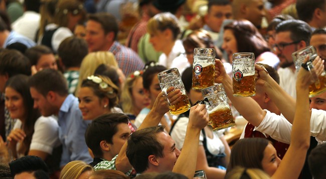 People cheer during the opening of the 182. Oktoberfest beer festival in Munich, southern Germany, Saturday, Sept. 19, 2015.