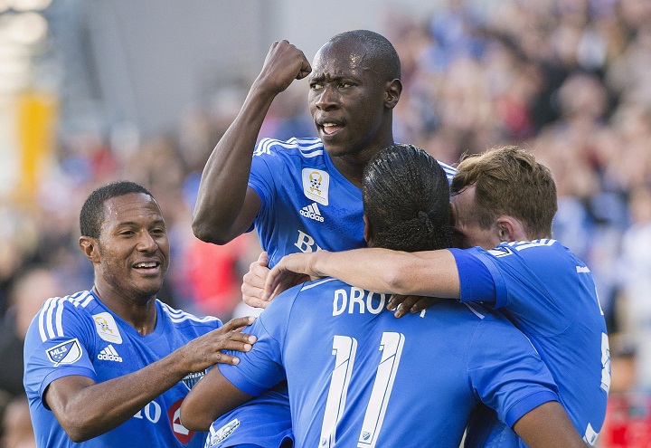 Montreal Impact's Didier Drogba (11) celebrates with teammates, from left, Patrice Bernier, Hassoun Camara and Wandrille Lefevre after scoring against D.C. United during first half MLS soccer action in Montreal, Sept. 26, 2015. 