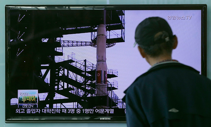 A South Korean man watches TV news program showing file footage of the Unha rocket in North Korea. 