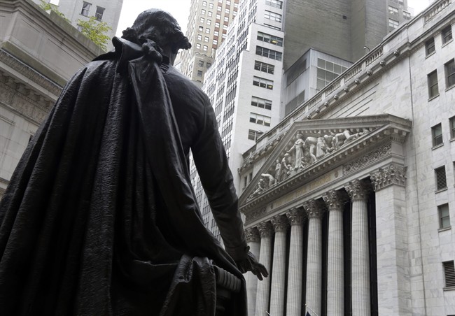 The statue of George Washington, on the steps of Federal Hall, faces the facade of the New York Stock Exchange. World stock markets await word of whether or not U.S. interests are about to tick higher for the first time in nearly a decade.