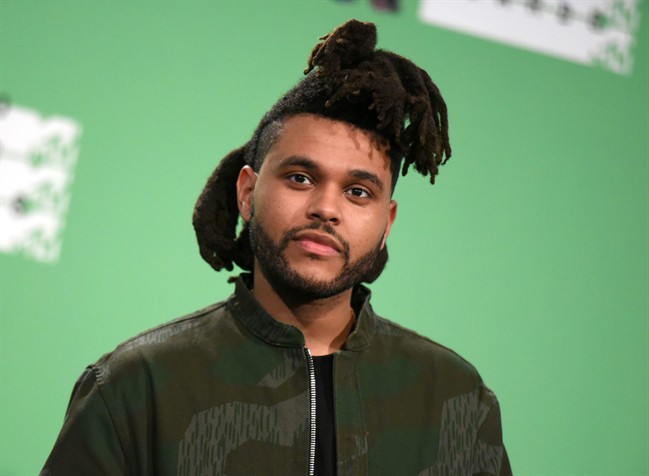 In this Aug. 30, 2015 file photo, The Weeknd poses in the press room at the MTV Video Music Awards in Los Angeles. 