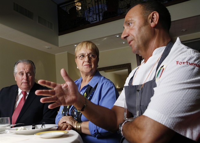 In this Sept. 17, 2015 photo, restaurateur Angelo Vivolo, and owner Lidia Bastianich, center, listen as Felidia executive chef Fortunato Nicotra, right, describes the food they plan to serve Pope Francis during his time in New York.