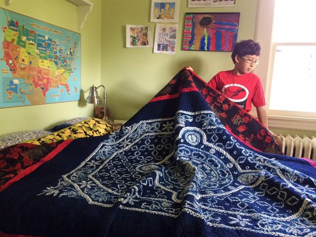 This photo shows, Kenji Kono, 10, who enjoys making his bed with quilts made by his grandmother, Uta Roth, on Tuesday, Sept. 1, 2015, in Larchmont, N.Y. 