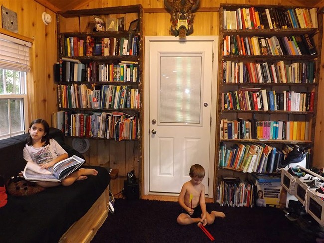 In this 2015 photo provided by Laura Baird, Jessica Baird, left, and her brother Evan relax in the living room of their family's 440-square-foot cabin on wheels in Myrtle Beach, S.C.