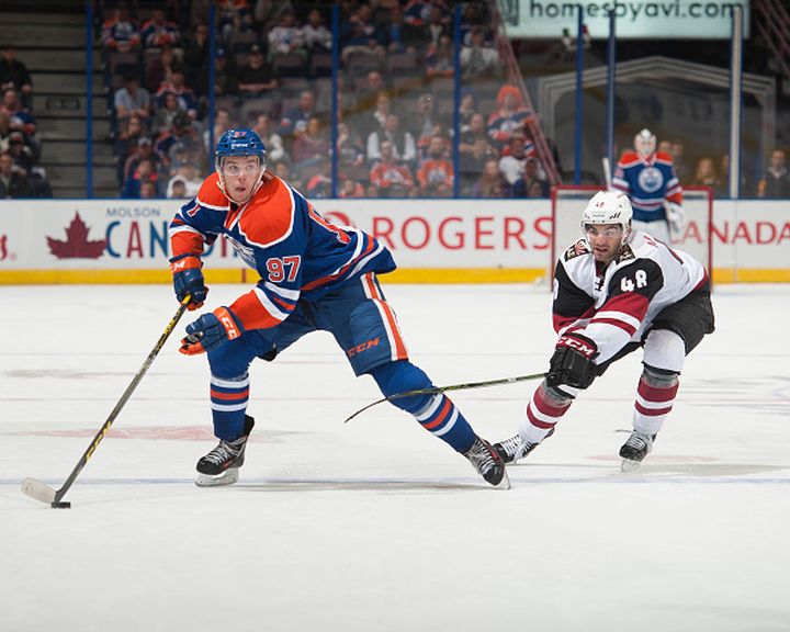 Connor McDavid #97 of the Edmonton Oilers skates with the puck while being pursued by Jordan Martinook #48 of the Arizona Coyotes on September 29, 2015 at Rexall Place in Edmonton, Alberta, Canada. 