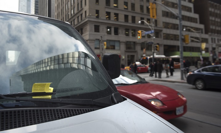 A parking ticket is stuck under the wiper blade of a van parked illegally on Adelaide Street West near Bay Street.