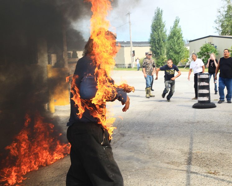 Pierre George, the brother of killed protester Dudley George, is engulfed in flames after attempting to pour gasoline on a fire during a protest against a community march intended to "walk home" to the gates of the former Camp Ipperwash on Sunday, Sept. 20, 2015, in London, Ontario. 