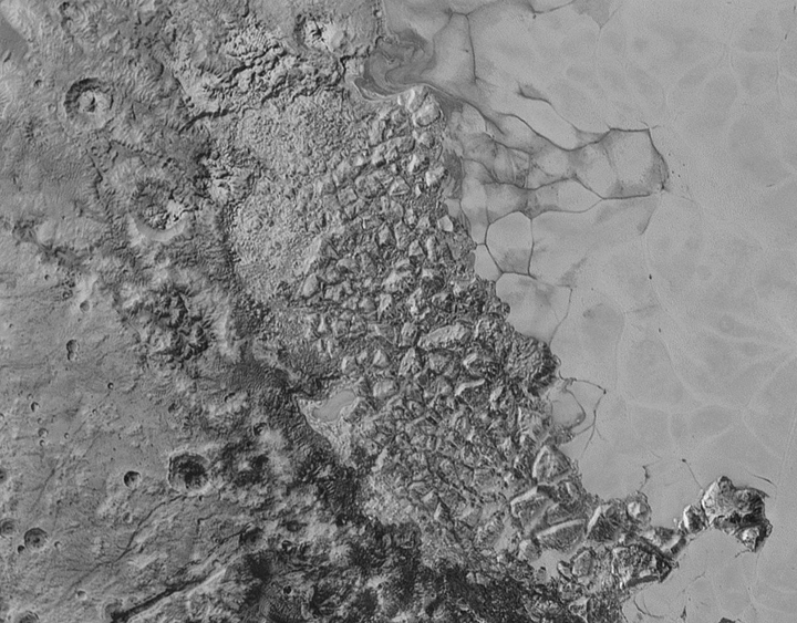 In the centre of this 470-kilometre-wide image of Pluto from New Horizons is a large region of jumbled, broken terrain on the northwestern edge of the vast, icy plain informally called Sputnik Planum, to the right.