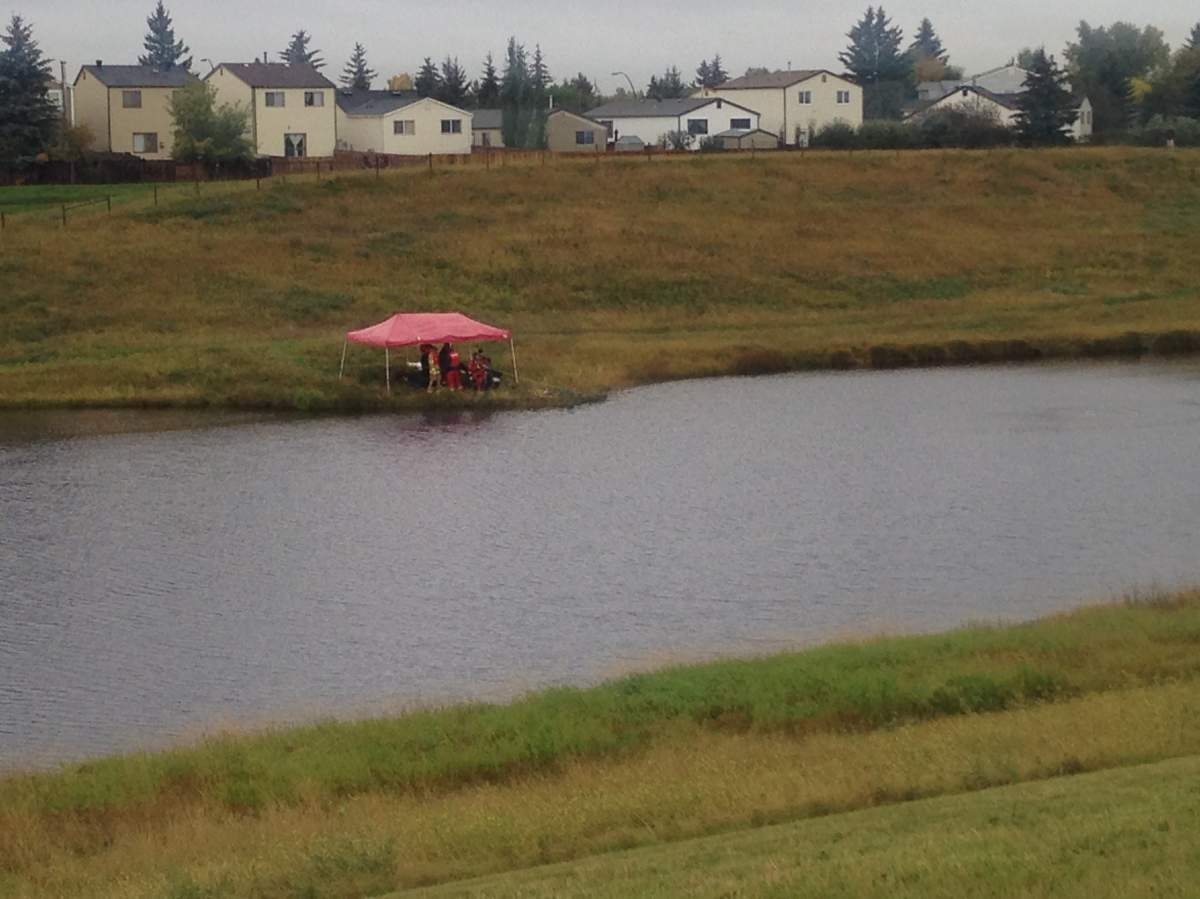 Drivers search for evidence related to the death of Colton Crowshoe in a pond on Monday, Sept. 14, 2015.